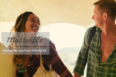 Surfing couple in underpass at Newport Beach, California, USA