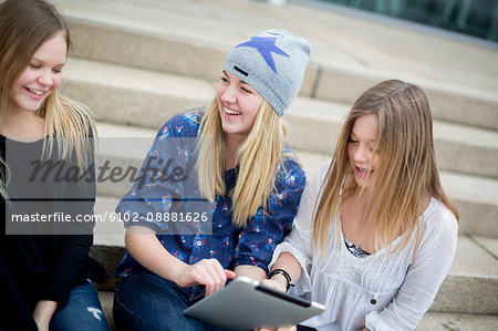 Smiling girls using digital tablet