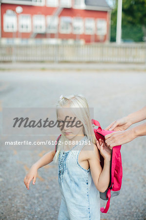 Girl putting backpack on