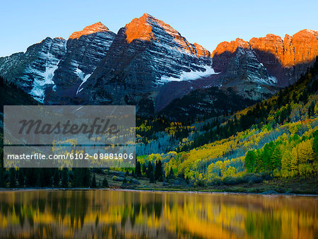 Autumn forest reflecting in mountain lake