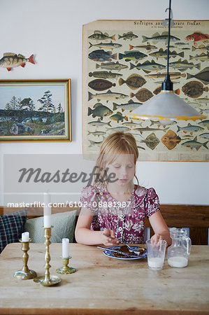 Girl eating by table