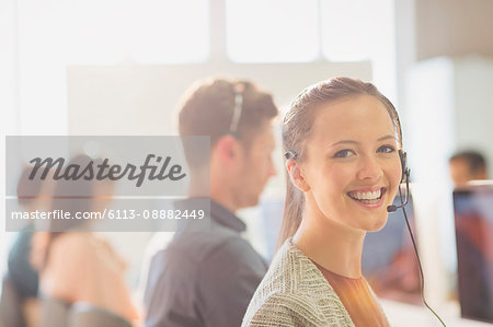Portrait smiling female telemarketer wearing headset in office