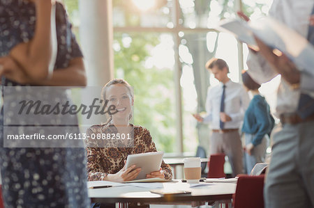 Portrait smiling businesswoman using digital tablet in office