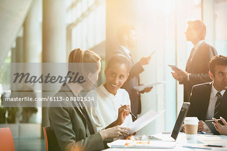 Businesswomen discussing paperwork in conference room meeting