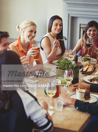 Friends talking and dining at restaurant table