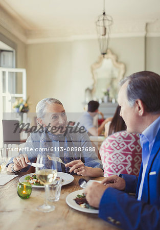 Senior couple talking and dining at restaurant table