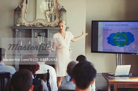 Businesswoman leading conference presentation at television screen