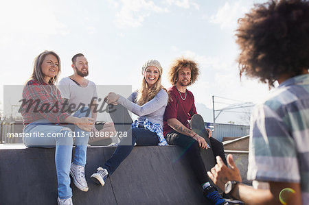 Friends hanging out and talking at sunny skate park