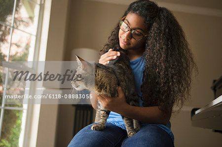 A girl with a cat on her lap.
