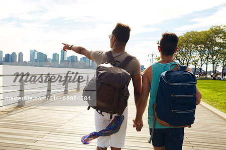 Young male couple strolling along East river waterfront, New York, USA