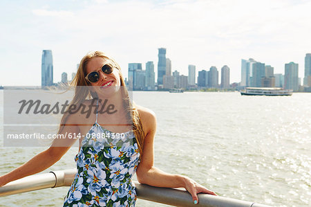 Portrait of young woman on skyline waterfront, New York, USA