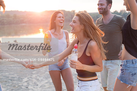 Group of friends drinking, enjoying beach party