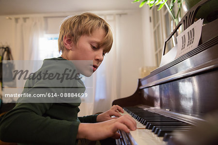 Boy playing piano in living room