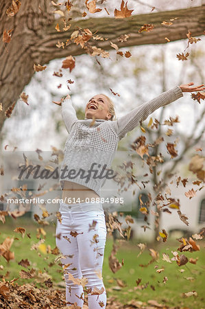 Woman playing with fallen leaves