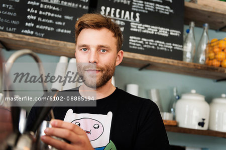 Young male barista in cafe
