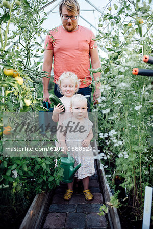 Father with daughters in greenhouse
