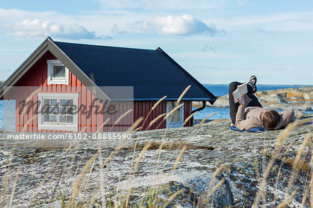 Woman reading book at coast