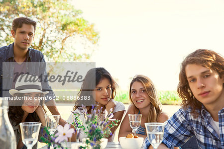 Friends enjoying meal together outdoors, portrait