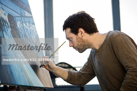 Artist working on oil painting in art studio