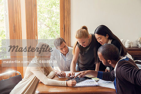 Colleagues looking at digital tablet together in office