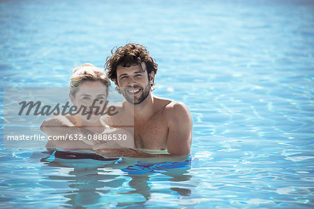 Couple relaxing together in pool, portrait