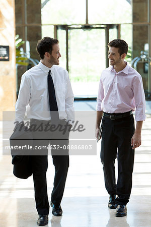 Business colleagues chatting while walking together