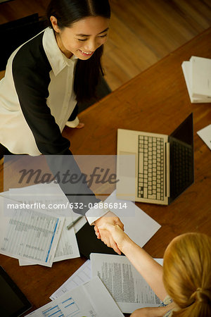 Businesswomen shaking hands during meeting