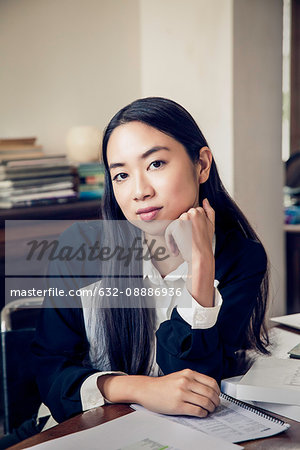 Woman sitting at desk in office, portrait