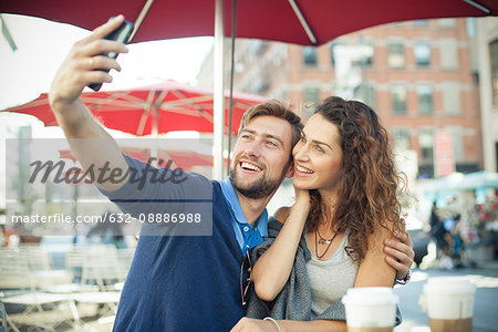 Couple posing for a selfie at outdoor cafe