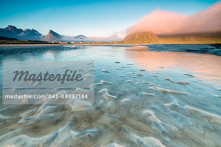 High peaks and midnight sun are reflected in the cold sea, Fredvang, Moskenesoya, Nordland county, Lofoten Islands, Norway, Scandinavia, Europe