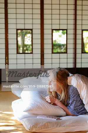 Caucasian woman wearing yukata in traditional Japanese house futon