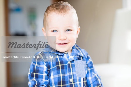 adorable toddler with blue eyes smiling and enjoying time at home
