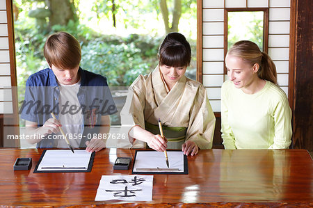 Caucasian couple practicing calligraphy at traditional Japanese house