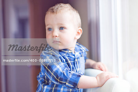adorable toddler with blue eyes being serious and enjoying time at home, toned image