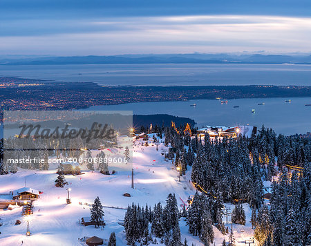 View from top of ski hill overlooking city lights dusk