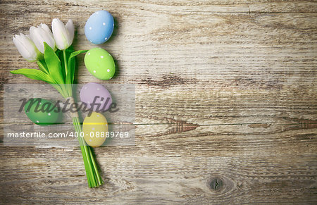 Easter eggs with bunch tulips copyspace on wooden board