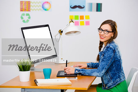 Woman working at desk In a creative office, using a computer