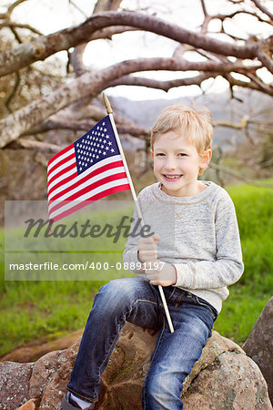 smiling caucasian boy holding american flag celebrating 4th of july, independence day