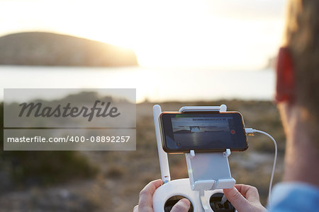 Close Up Of Man Flying Drone Over Coastal Landscape