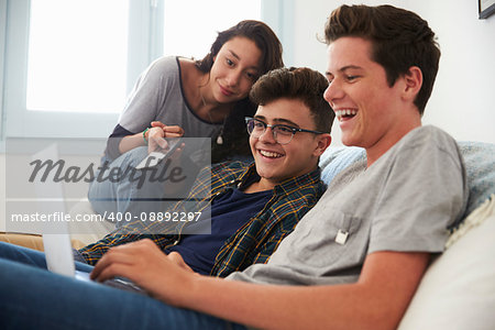 Teenage friends watching something funny on laptop computer