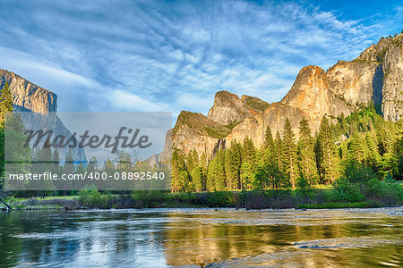Granite cliffs reflecting in Merced river during dusk, Yosemite National Park. California, USA