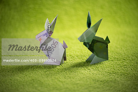 origami hare from banknotes a green background