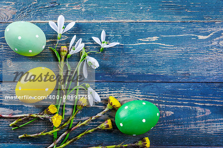 Easter eggs and spring flower snowdrop on old wooden blue board ustic style top view. Copyspace. Greeting card