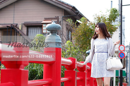 Fashionable Japanese woman walking on traditional bridge, Tokyo, Japan