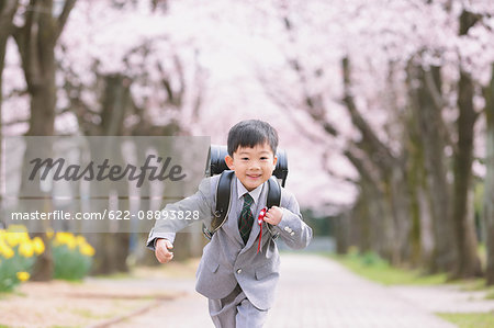 Japanese kid with cherry blossoms in a city park