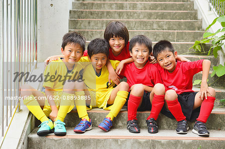 Japanese kids in soccer uniform on a staircase