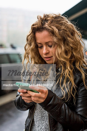 Woman in street looking at smartphone