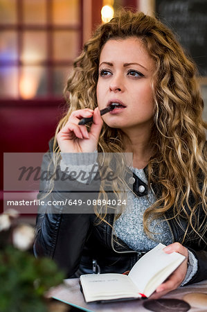 Woman at cafe writing in notebook