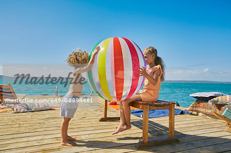 Boy and girl playing with beach ball on houseboat sun deck, Kraalbaai, South Africa