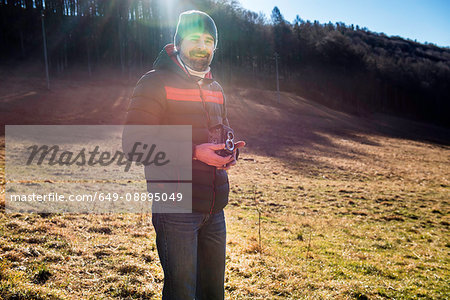 Portrait of man in rural setting, holding medium format camera, Italy